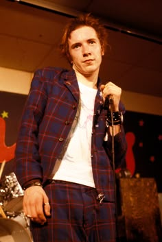 a man in plaid jacket holding a microphone