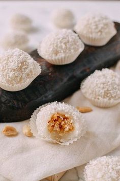 some white desserts are sitting on a napkin with nuts and powdered sugar around them