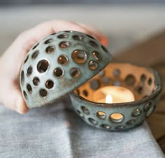 a person holding a tea light holder in their hand