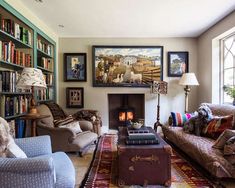 a living room filled with lots of furniture and bookshelves next to a fire place