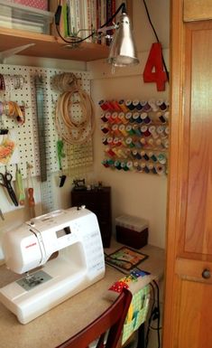 a sewing machine sitting on top of a table next to a wooden cabinet filled with craft supplies