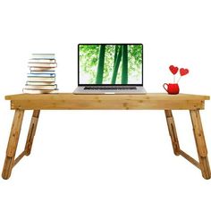 a laptop computer sitting on top of a wooden desk with stacks of books next to it