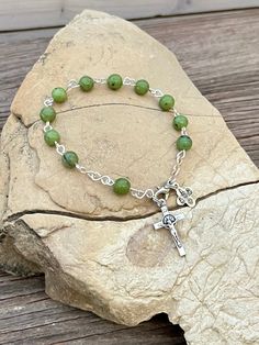 "Beautifully Handmade Rosary bracelet! Beads are 6mm polished (Peridot Green) Nephrite Jade semi-precious stone, Cross is a 7/8\" silver St. Benedict crucifix, and mini medal is a 1/2\" mini medal with amazing details **Mini Medal Choices** 1. Blue Miraculous Mary 2. Miraculous Mary 3. Holy Spirit 4. 5 Way Cross 5. Holy Family / Holy Spirit 6. Guardian Angel / St. Michael Each one of my rosary bracelets starts its life as a spool of wire and a handful of beads. It is carefully assembled one link Rosary Bracelet Catholic, Mini Rosaries, Handmade Rosary, Stone Cross, Decade Rosary, St Benedict, Catholic Rosary, Peridot Green, Rosary Bracelet