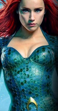 a woman with red hair and blue dress in the shape of a mermaid is shown