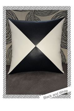 a black and white pillow with an abstract design on the front, along with a striped background