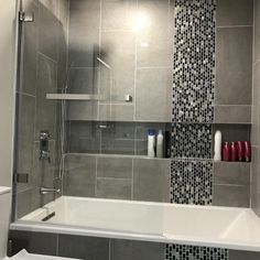 a bathroom with gray tile and white fixtures