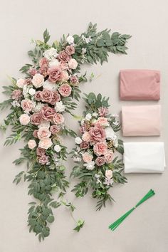 flowers and greenery laid out on the floor next to each other, including pink roses