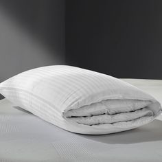 an unmade bed with two pillows on top of it and a pillow in the middle