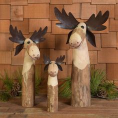 three wooden moose figurines are standing next to each other