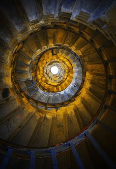 a spiral staircase with light coming from the top