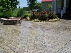 an outdoor patio with brick pavers and stone fire pit