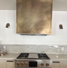 a stove top oven sitting inside of a kitchen next to a wall mounted range hood