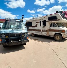 an rv parked next to a truck in a parking lot