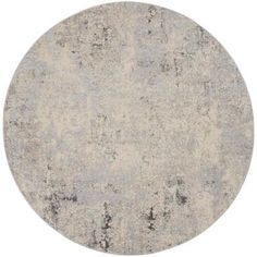 a round rug with an old, faded design in grey and white colors on a white background