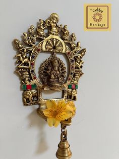 an ornate brass clock with a yellow flower in the center