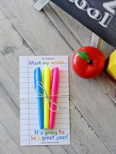 two colorful pens and an apple are next to a note that says it's going to be a great year