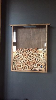 a wooden frame filled with lots of wine corks on top of a blue wall