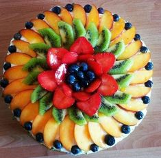 a fruit cake with kiwis, strawberries and blueberries on top