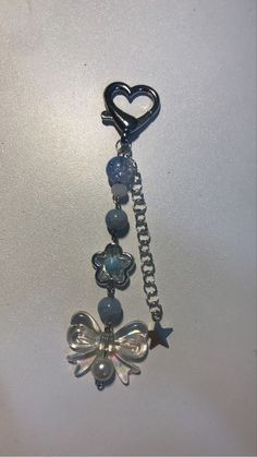 a key chain with charms attached to it on a white surface and a heart hanging from the end