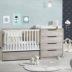 a baby's room with a crib, dresser and bed in grey tones