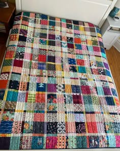 a multicolored patchwork quilt on a bed