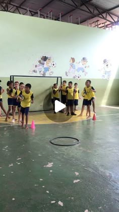 a group of young children standing on top of a basketball court next to each other