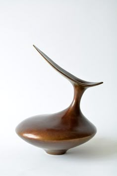 a brown vase sitting on top of a white table