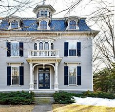 a large white house with blue shutters on the front