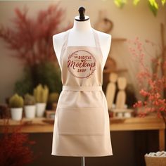 a white apron on a mannequin in front of a table with potted plants