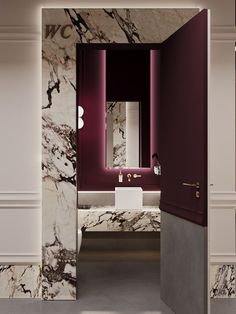 an open door leading to a bathroom with marble walls and flooring, along with a sink