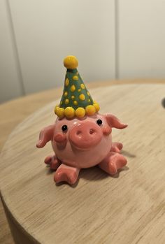 a pink pig with a party hat on it's head sitting on a table