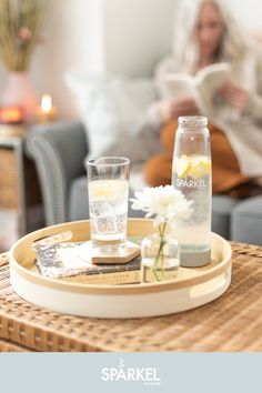 there is a tray with water and lemons on it, next to a vase