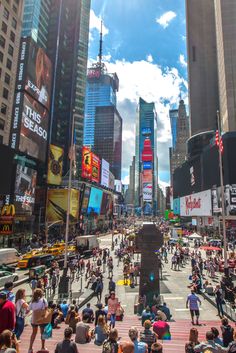 a crowded city street filled with lots of people and tall buildings on either side of it