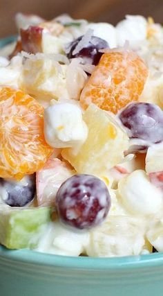 a blue bowl filled with fruit salad on top of a table