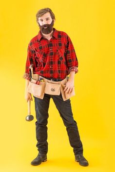 a man with a beard and tool belt standing in front of a yellow background wearing a red flannel shirt