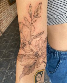 a woman's arm with a flower tattoo on it