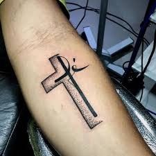 a cross tattoo on the arm with a knife sticking out of it's center