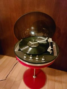 a record player sitting on top of a red stand