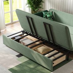 a couch that is sitting in the middle of a room with books on it and an open drawer underneath