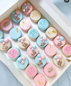 a box filled with lots of different types of buttons in pastel blue, pink and white