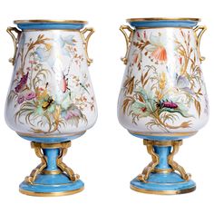 two vases with flowers painted on them sitting next to each other in front of a white background