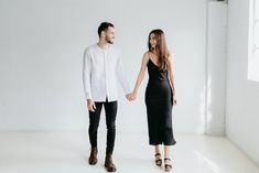 a man and woman holding hands in an empty room