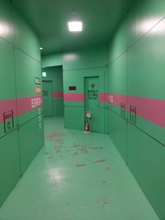 an empty hallway with pink and green walls