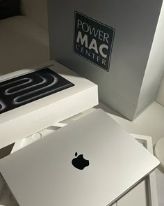 an apple computer sitting on top of a white table next to a power mac box