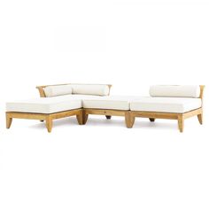 a wooden couch with white cushions sitting on it's back legs and armrests