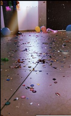 the floor is littered with confetti and balloons