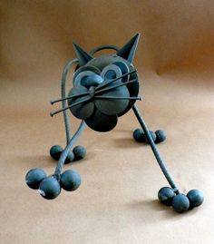 a paper mache cat made out of blue balls and wire on a brown background