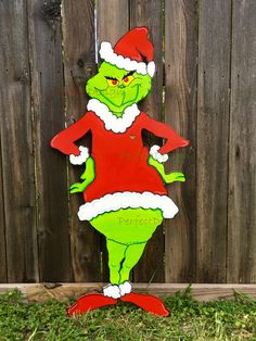 the grinch is standing in front of a fence