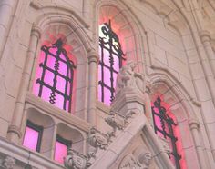 an ornate building with two large windows and red light coming through the window panes