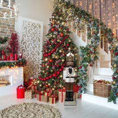 a decorated christmas tree in a living room with red and gold decorations on the stairs